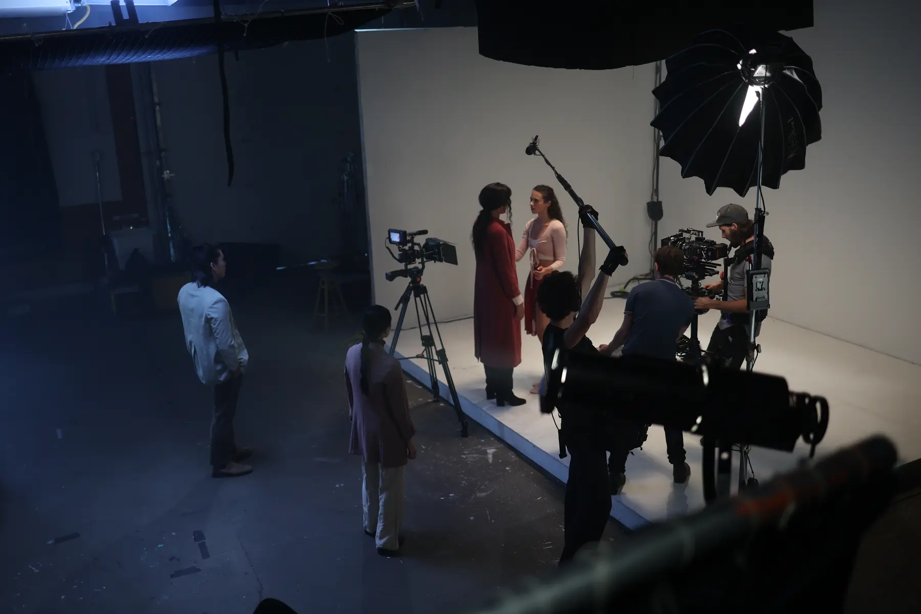 Crew filming performers on a greenscreen stage